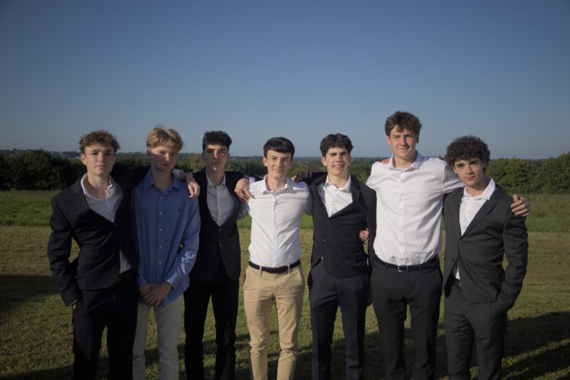 Des élèves prennent la pose pour une photo souvenir, vêtus de leurs plus beaux habits de gala.