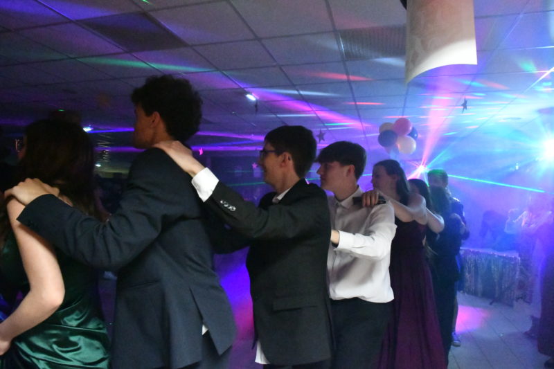 Les élèves rient et s'amusent ensemble lors d'une pause entre les danses, profitant pleinement de la soirée.
