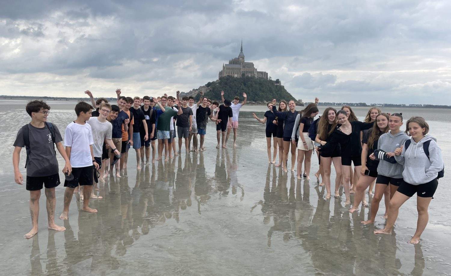Élèves de Seconde du Lycée Jean-Paul II traversant la baie du Mont-Saint-Michel sous le soleil, entre jeux, découvertes historiques et franchissement des sables mouvants.