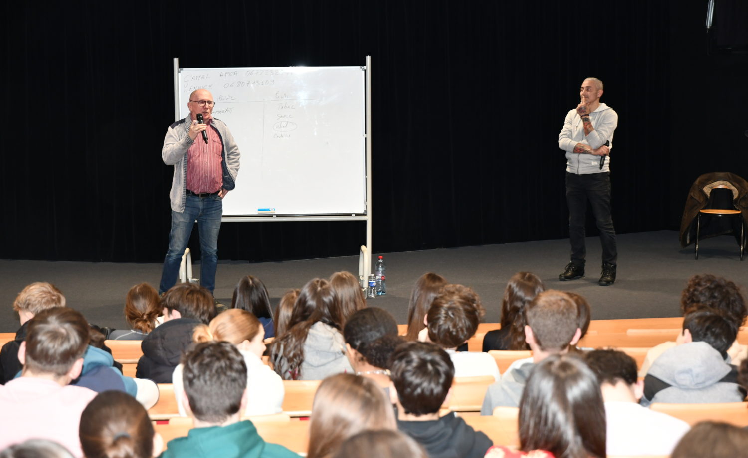 Deux intervenants, Camel GUELLOUL et Yannick LOISEL, s'adressant à une classe de seconde pour sensibiliser les élèves aux dangers de l'alcool et des drogues à travers des témoignages poignants et des récits d'expérience.