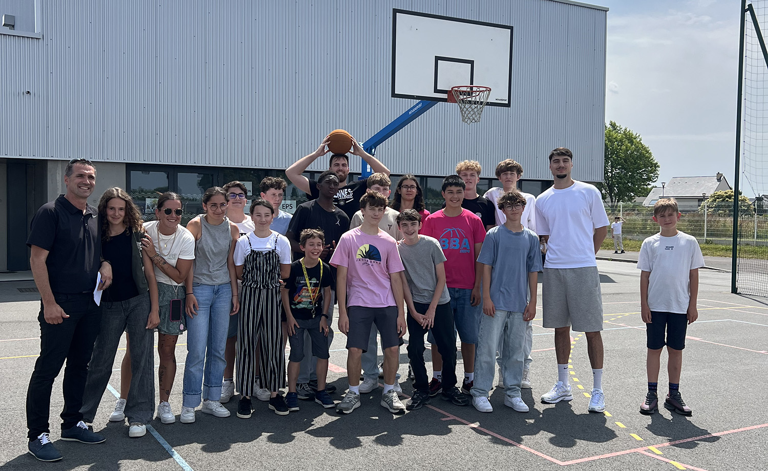Joueurs de l’Union Rennes Basket encadrant des élèves du Collège Immaculée lors d’une initiation au basket en 3x3 dans la cour du collège.