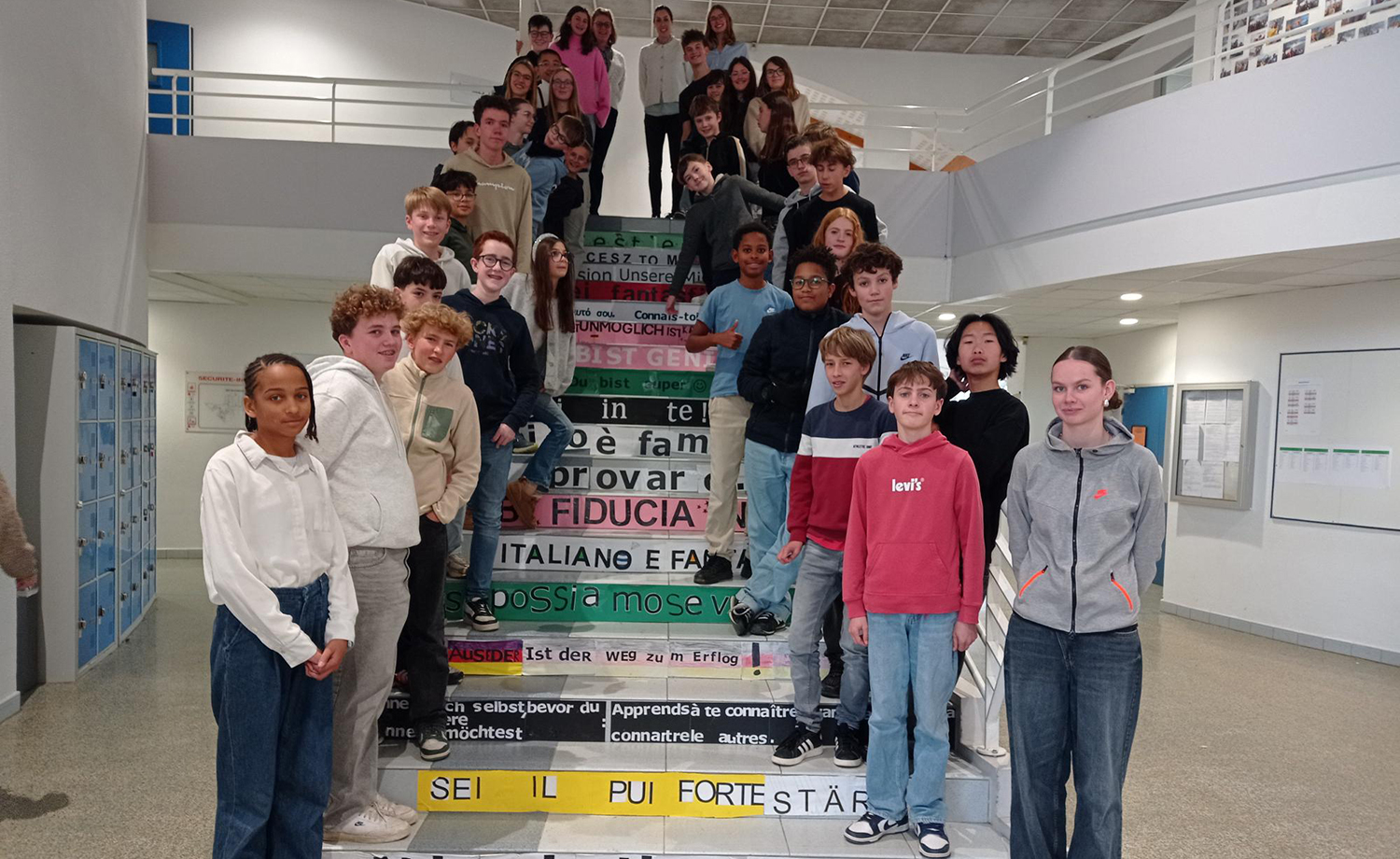 Élèves du Collège Immaculée installant des phrases multilingues sur les marches de l’escalier dans le cadre du projet "Les marches de la réussite".