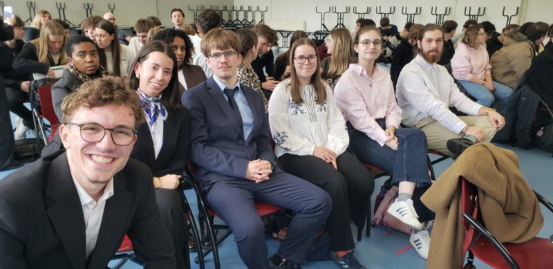 Étudiants participant à un concours d’éloquence devant un jury.